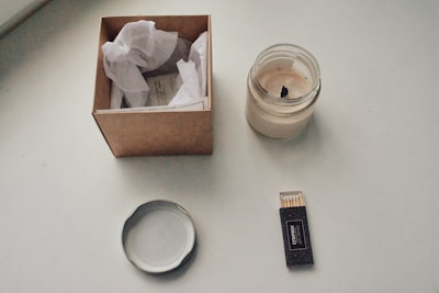 A stylish box open to reveal self-care items like candles and bath salts, set on a minimalist white background.
