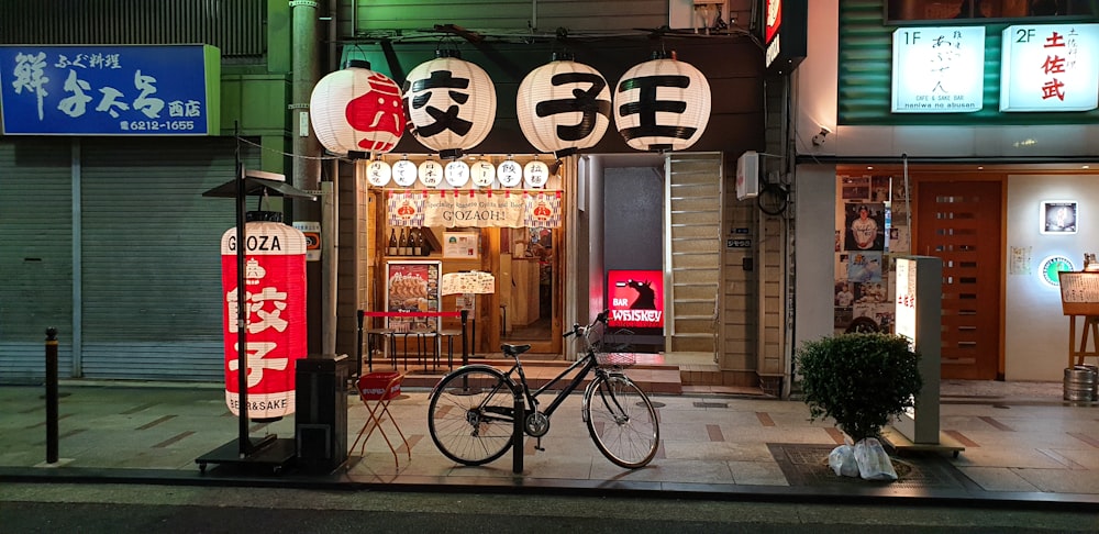 red and black bicycle parked beside store during daytime