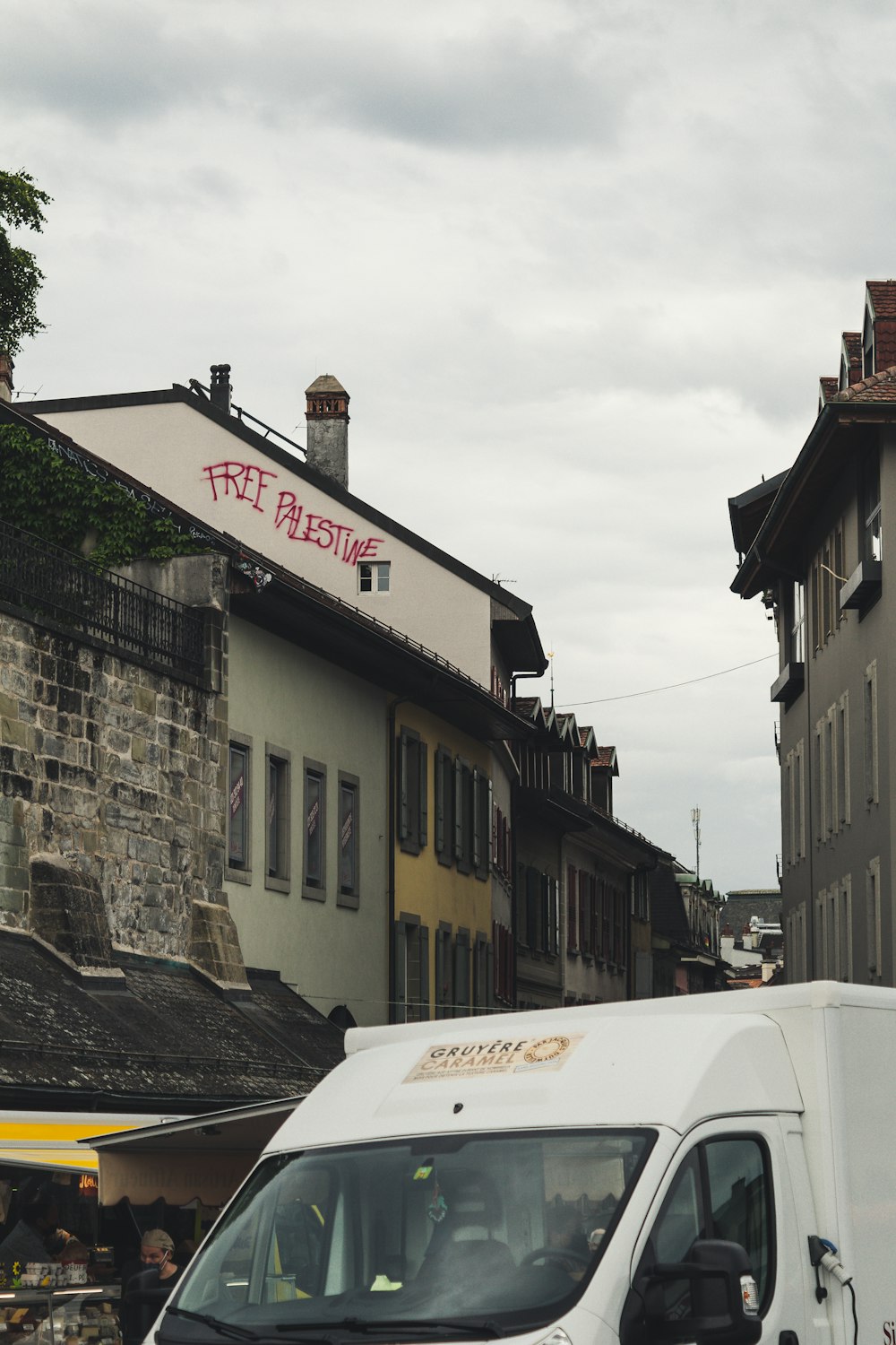 Camionnette blanche garée à côté d’un bâtiment en béton gris pendant la journée