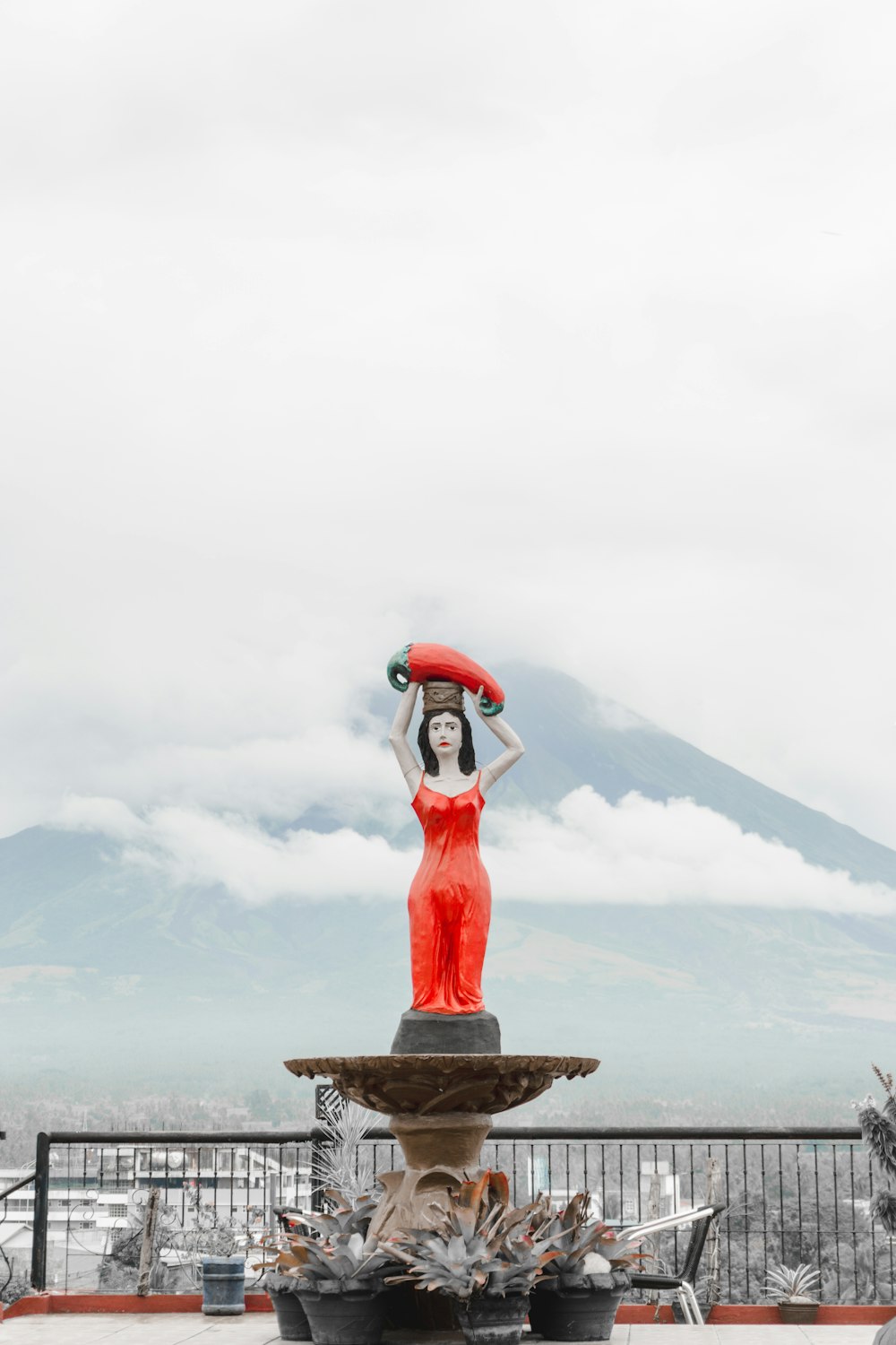 brown statue on gray rock near snow covered mountain during daytime