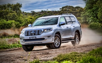 gray mercedes benz suv on brown dirt road during daytime