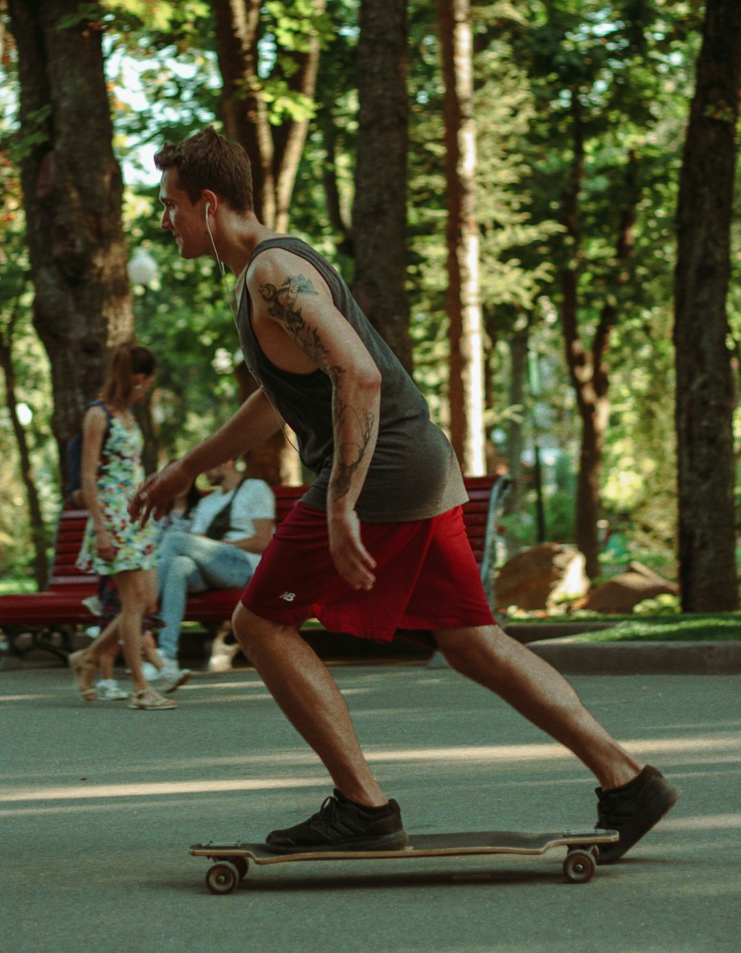 man in white and black nike tank top and red shorts running on track field during