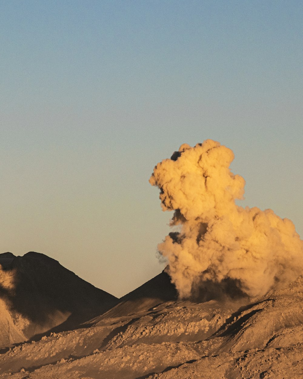 white clouds over brown mountain