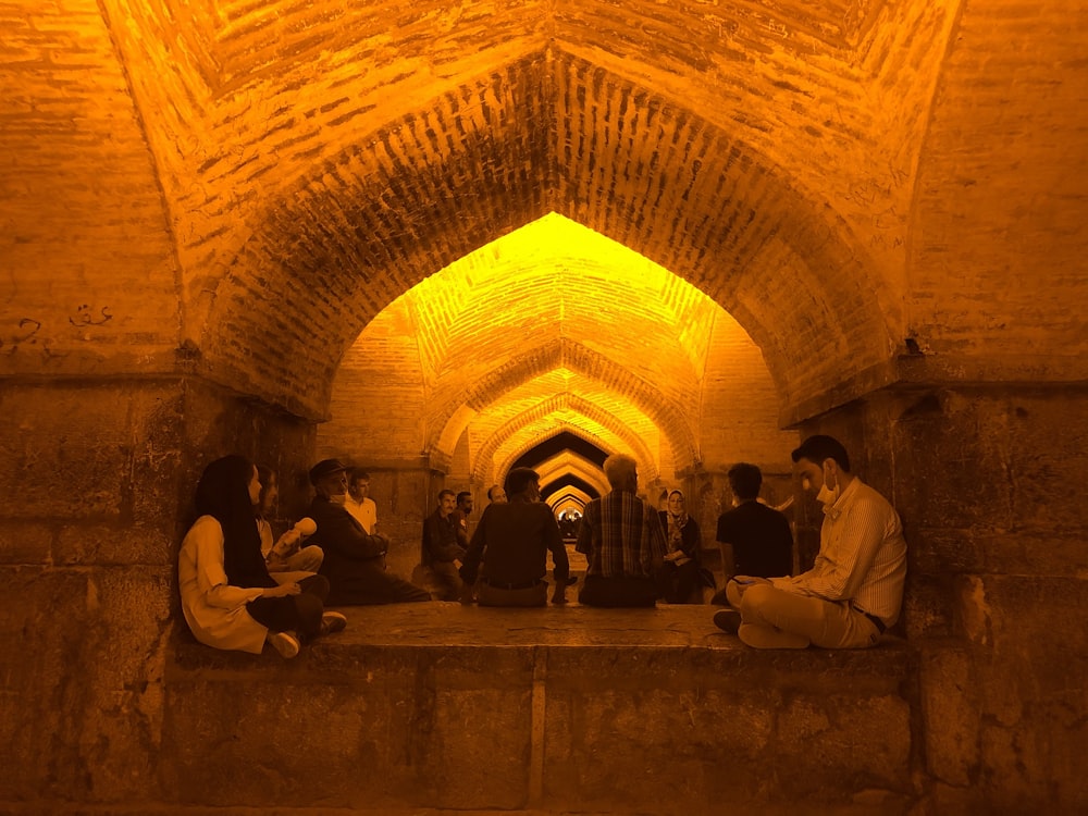 people sitting on brown concrete building