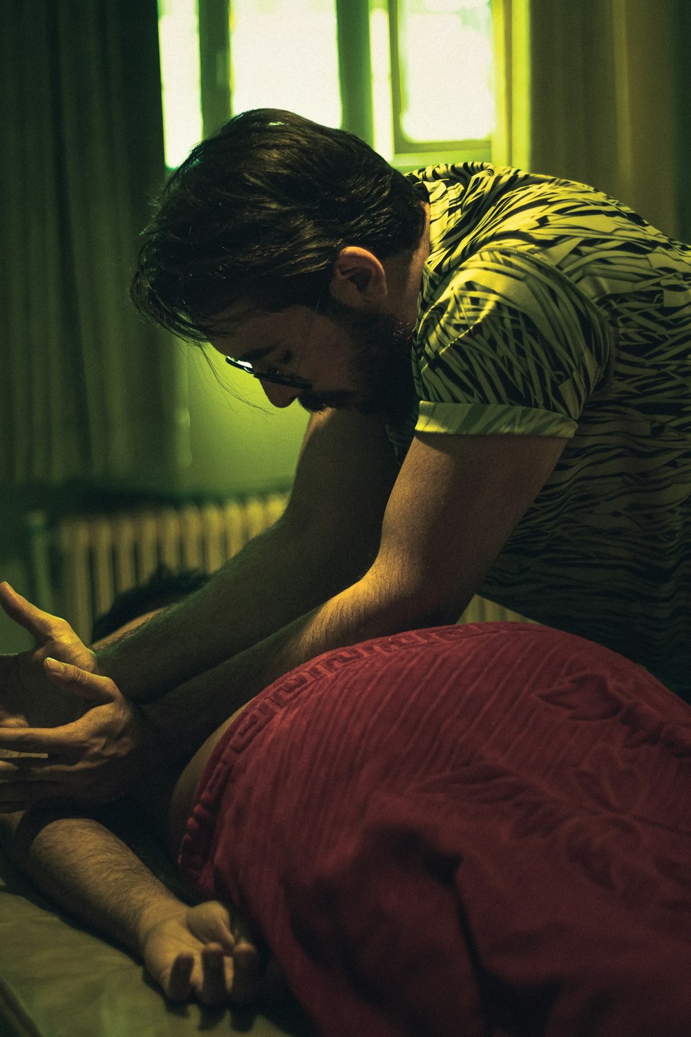 man in brown and white stripe shirt sitting on bed