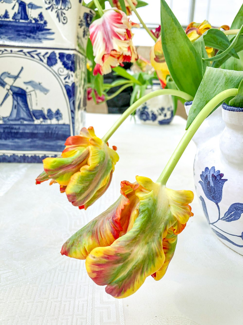 yellow and green flower on white and blue ceramic vase