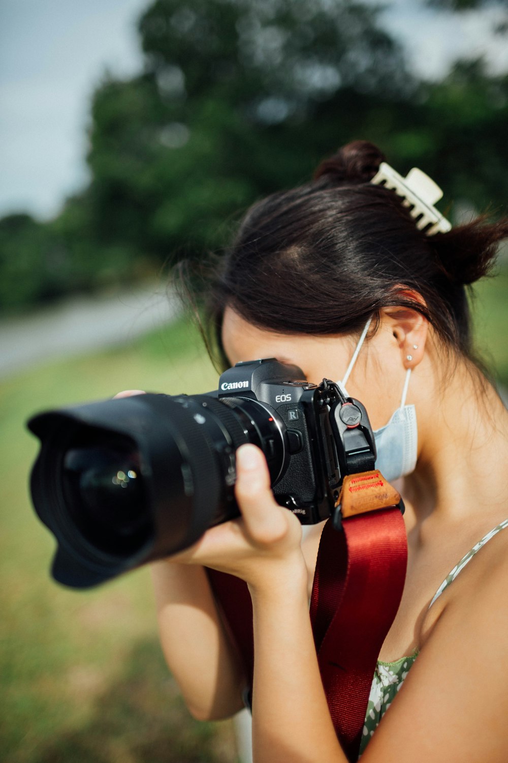 woman in white tank top holding black dslr camera