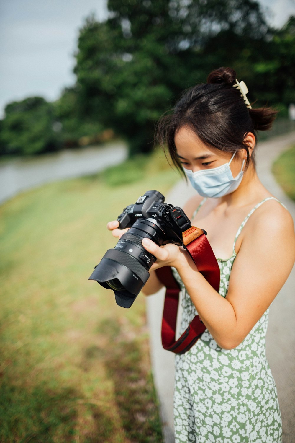 woman in white tank top holding black dslr camera