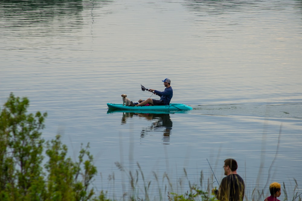 man and woman riding on blue kayak on lake during daytime