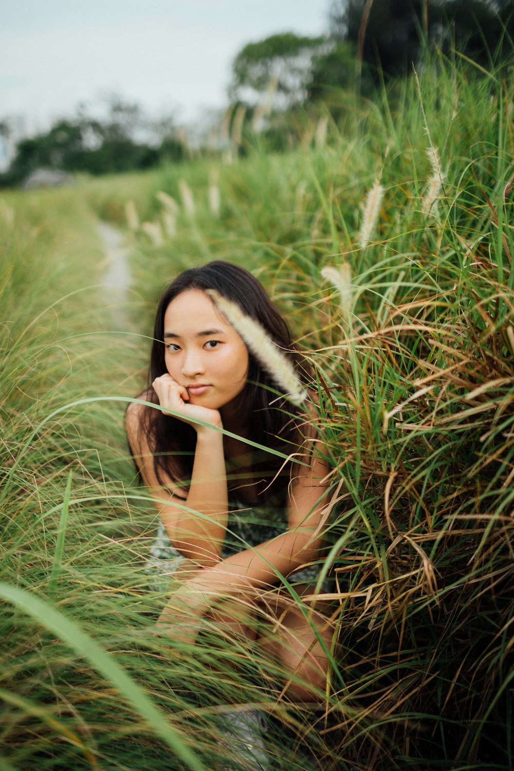 woman in black tank top lying on green grass during daytime