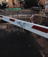 A simple construction barrier with a caution sign on a quiet street.