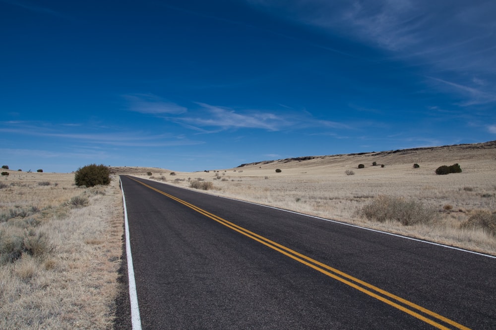 gray asphalt road under blue sky during daytime