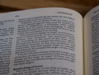 A close-up image of an open book, showcasing a section of text on biblical history involving kings and events. The page numbers and some headings are visible, emphasizing the context of the Old Testament.