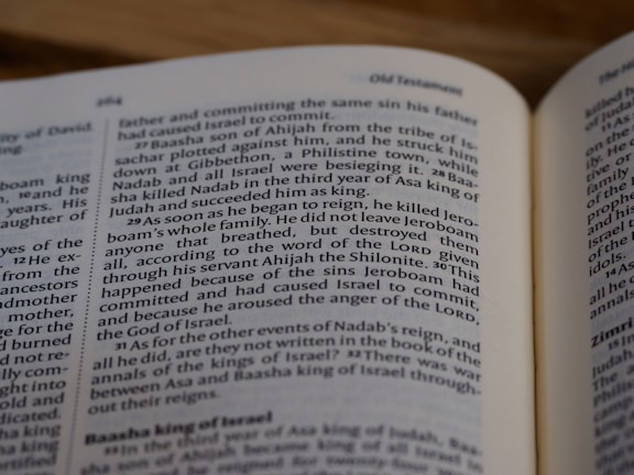A close-up image of an open book, showcasing a section of text on biblical history involving kings and events. The page numbers and some headings are visible, emphasizing the context of the Old Testament.