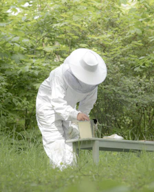 person in white long sleeve shirt and white pants holding white ceramic mug