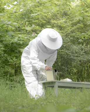 person in white long sleeve shirt and white pants holding white ceramic mug