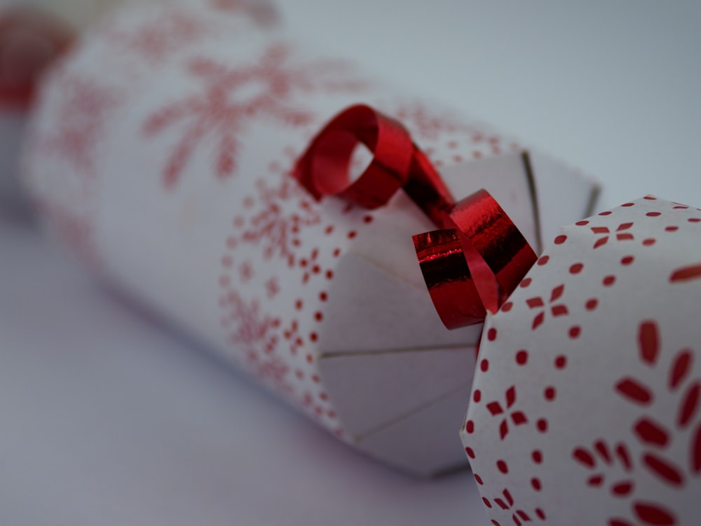 red ribbon on white and red heart print gift box