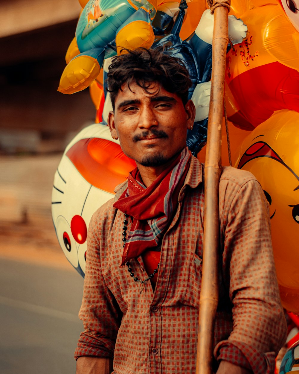 man in brown button up shirt holding yellow and red inflatable balloons