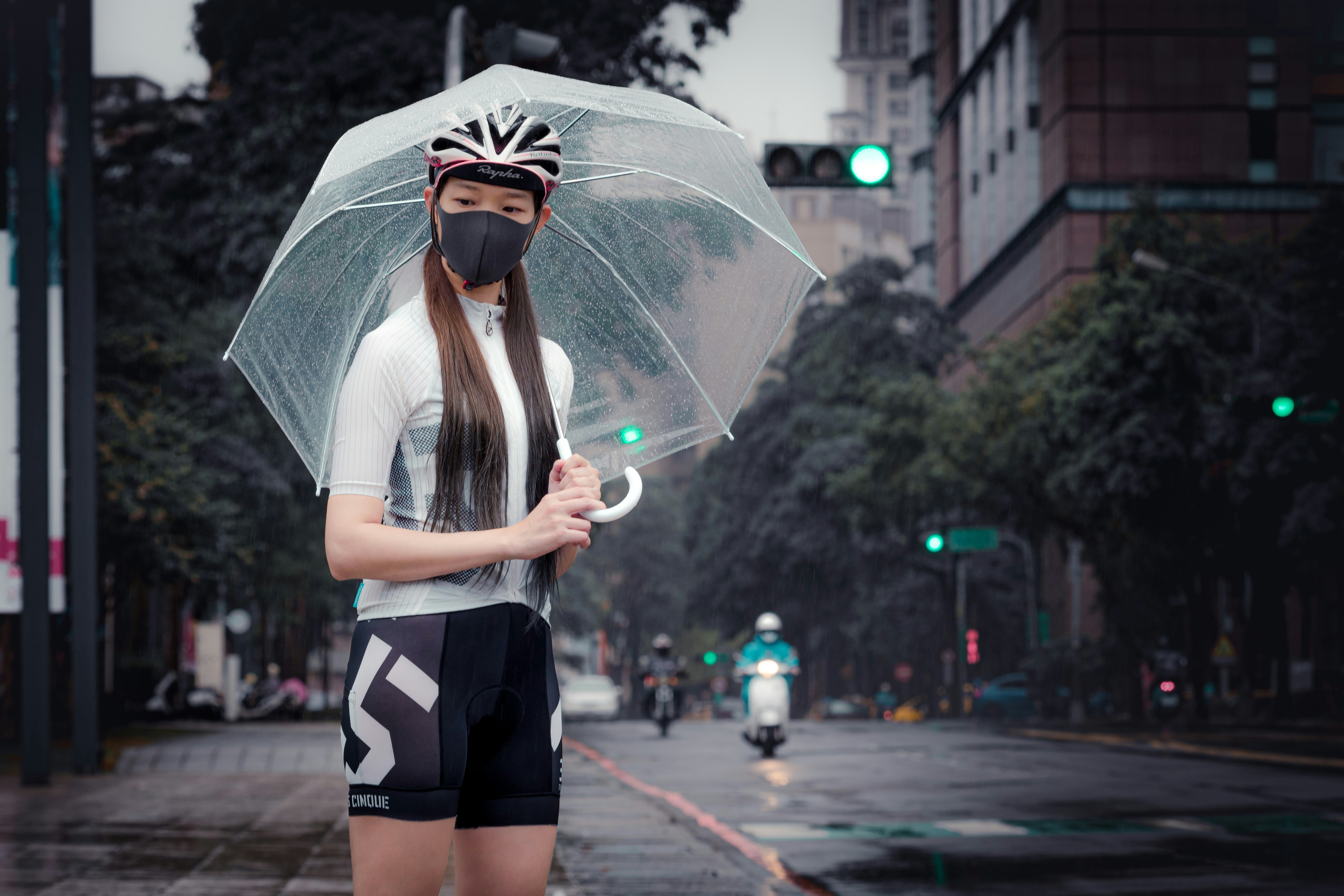 woman in gray shirt and black skirt holding umbrella
