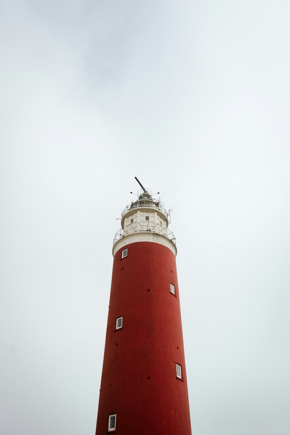 Phare rouge et blanc sous un ciel blanc