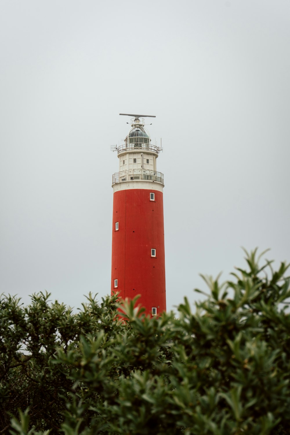 白い空の下の赤と白の灯台