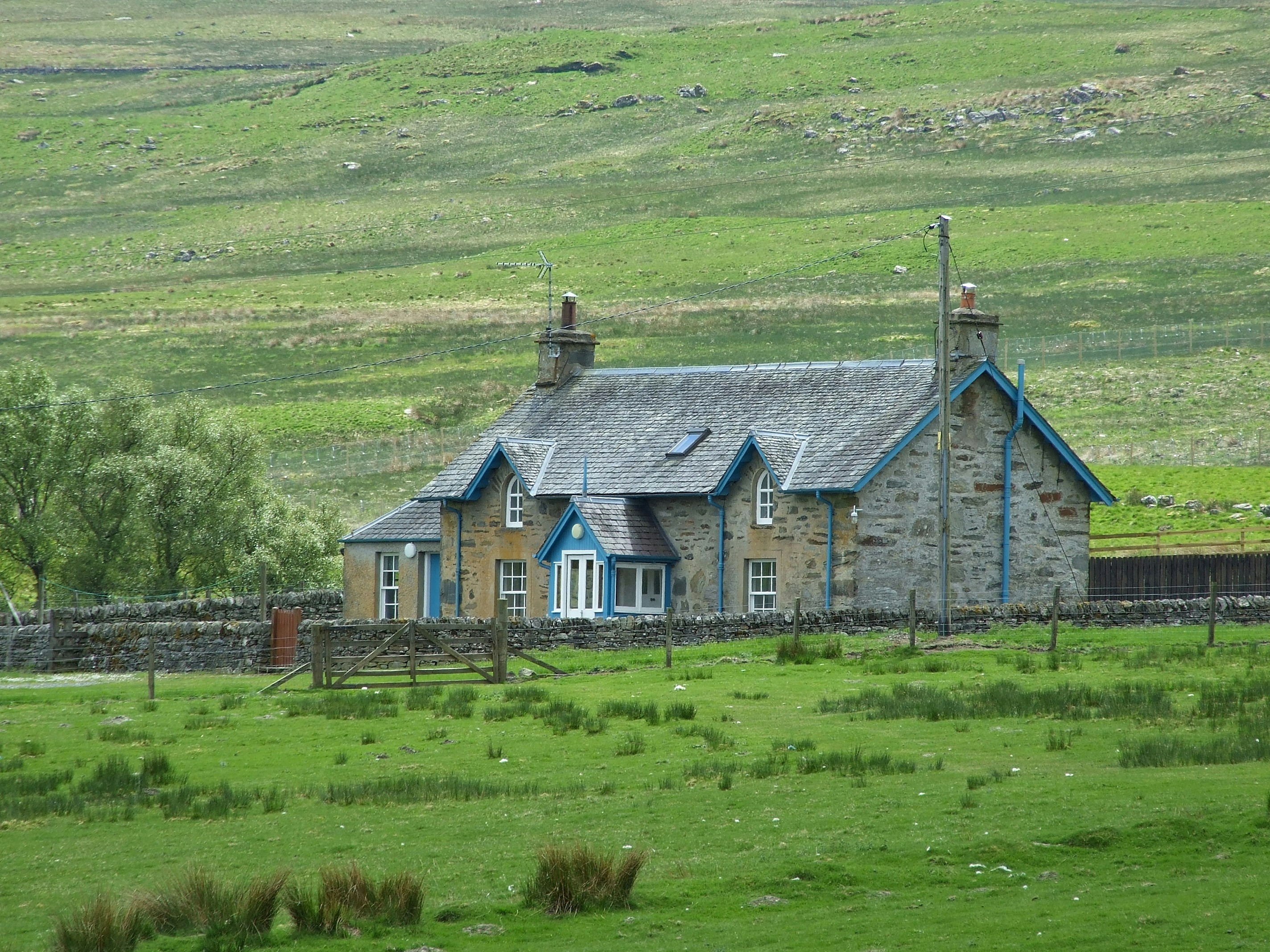 gray and white wooden house on green grass field during daytime