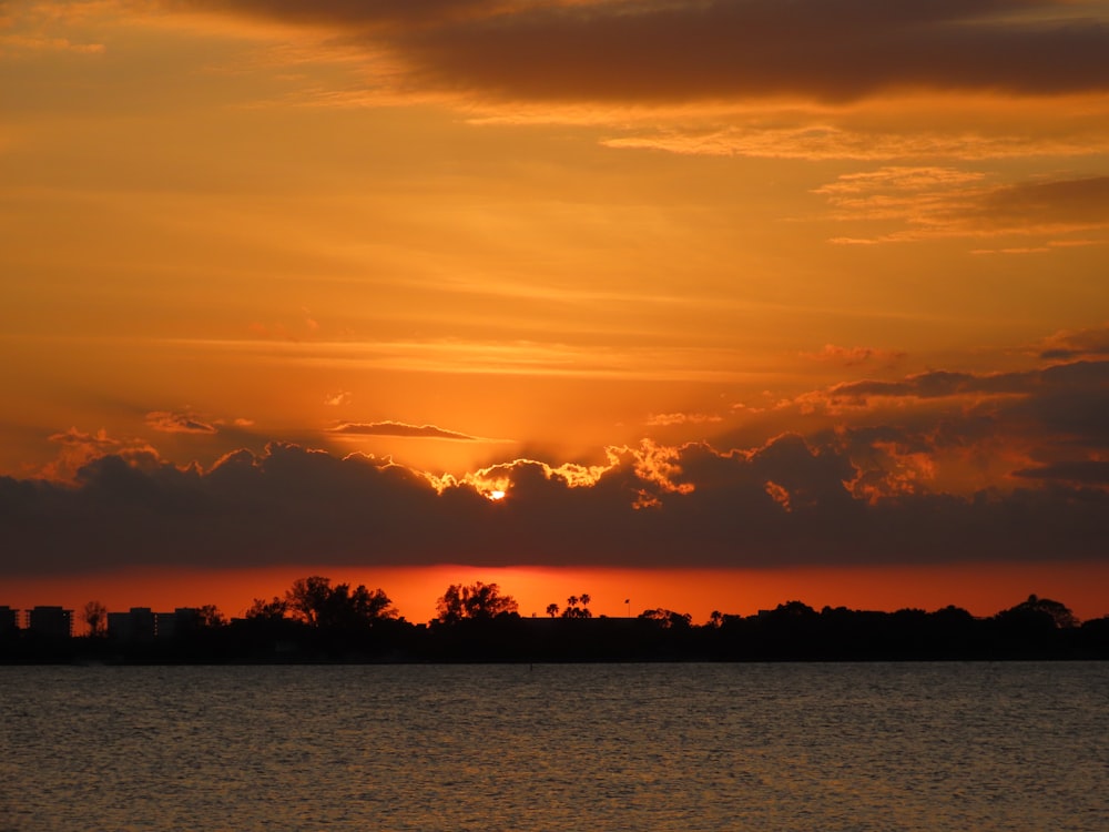 body of water under cloudy sky during sunset