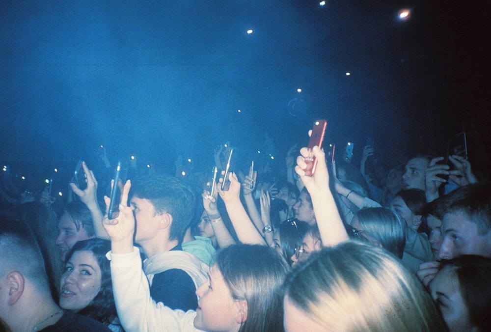 people raising their hands in front of crowd