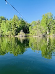 Fishing rod casting smoothly over a lake at sunrise.