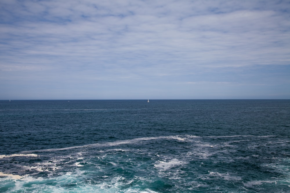 body of water under cloudy sky during daytime