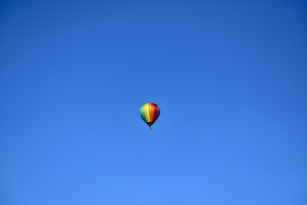 a hot air balloon flying through a blue sky