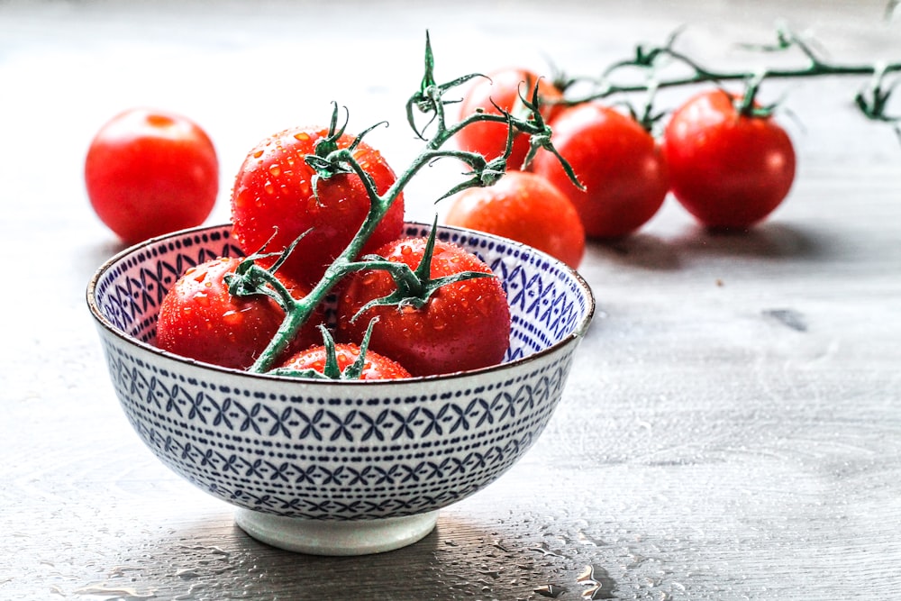 red cherry fruits on white ceramic bowl