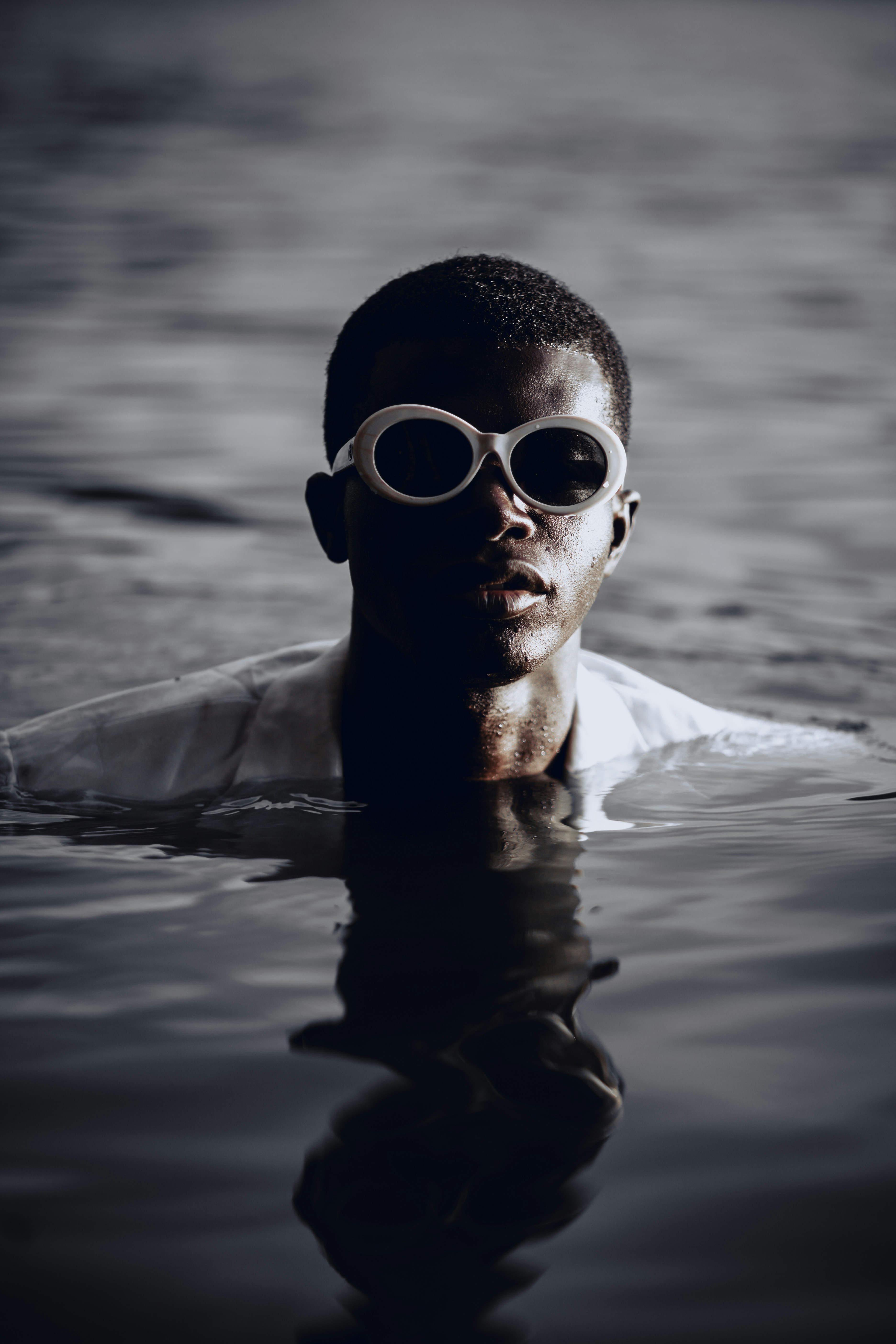 man in white dress shirt wearing black sunglasses in water