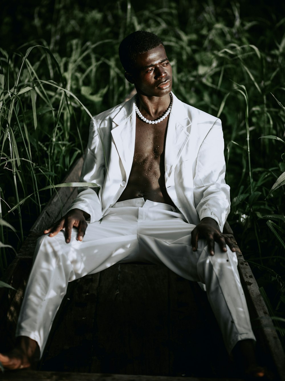 man in white suit sitting on black chair