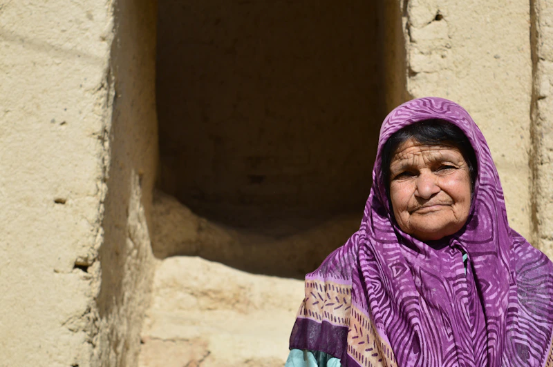 Indian woman in a purple scarf in front of a building