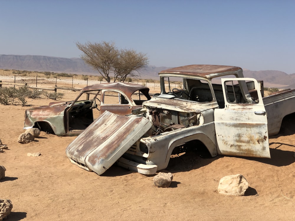 white and brown vintage car on brown sand during daytime