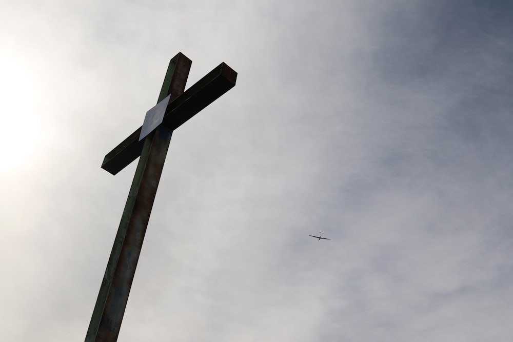 cruz de madeira marrom sob o céu cinzento