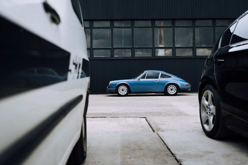 blue sedan parked beside white car