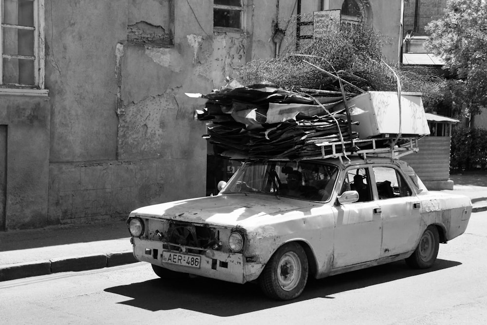 grayscale photo of car parked beside wall