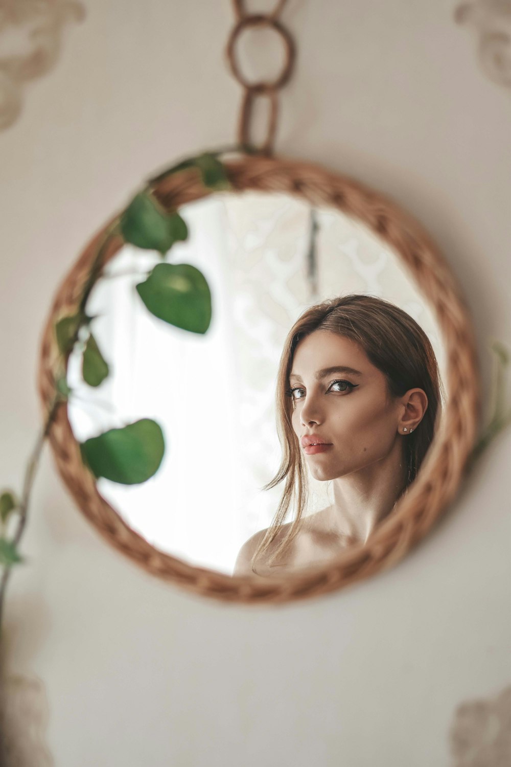 girl in white shirt lying on brown and green floral round bed