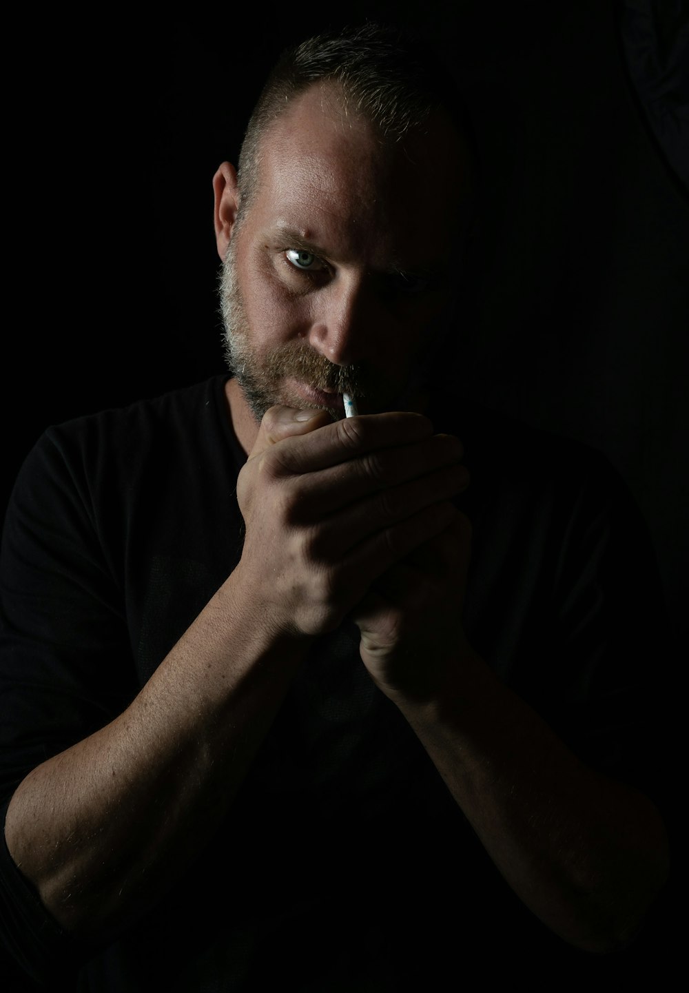 man in black crew neck shirt smoking cigarette