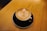 A close-up of a beautifully crafted coffee cup with latte art on a wooden table.