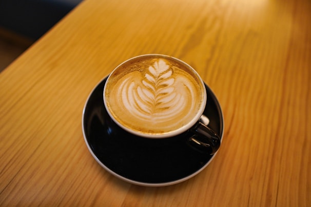 Close-up of a beautifully crafted coffee cup with latte art on a wooden table