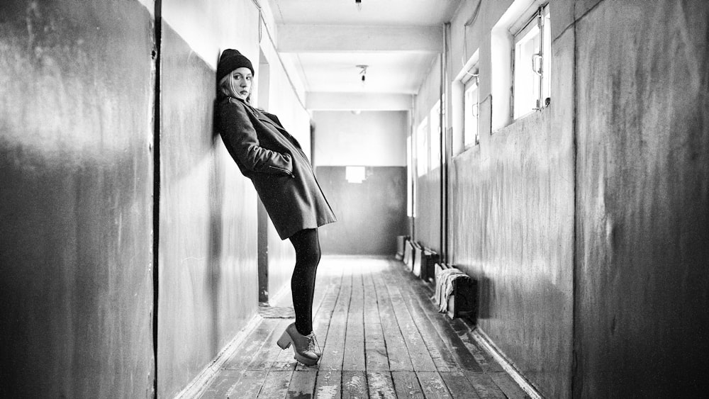 woman in black coat standing on hallway