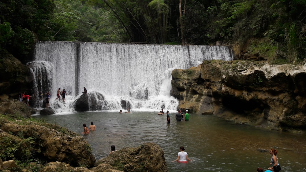people in water falls during daytime