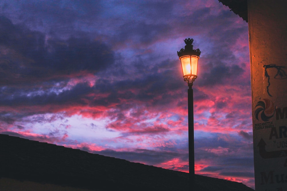 black street lamp under cloudy sky during night time