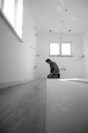 man in black jacket sitting on floor