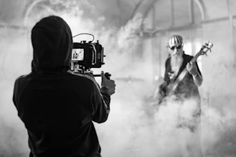 man in black jacket holding black camera