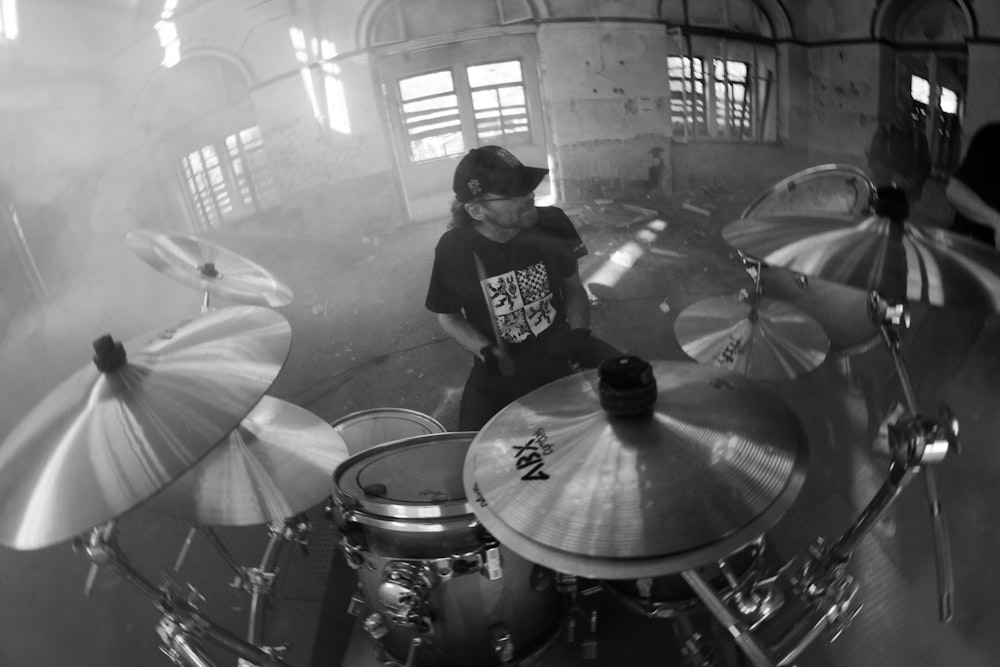 man in black and white crew neck t-shirt playing drum