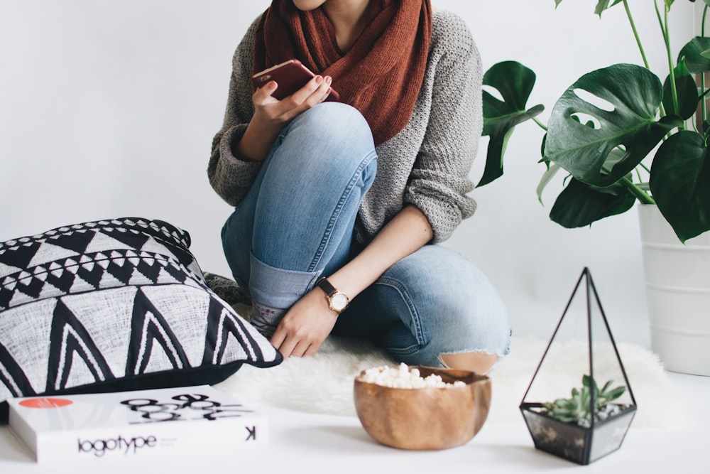 woman in blue denim jeans sitting on white table